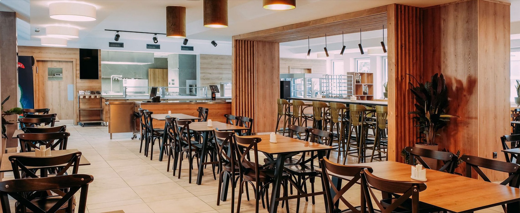 Svetlý interiér BistroMEX s drevenými lamelami, stolmi a samoobslužným pultom